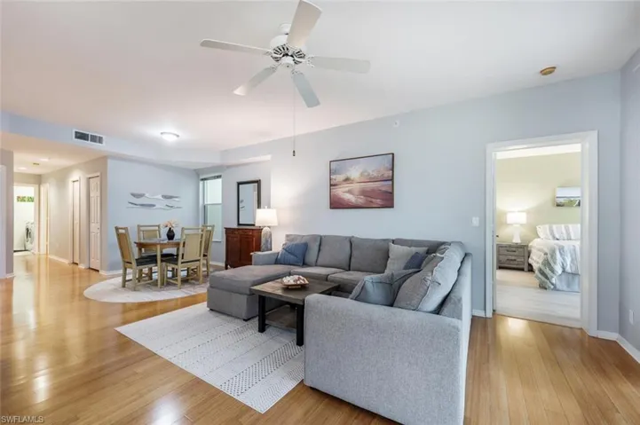 Living room with ceiling fan and light hardwood / wood-style flooring