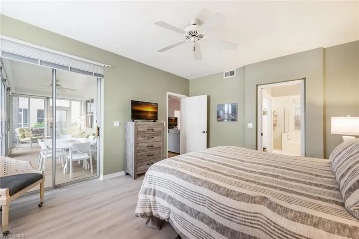Bedroom featuring ceiling fan, light hardwood / wood-style floors, and ensuite bath