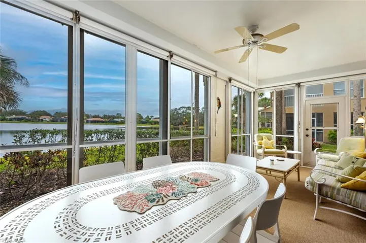 Sunroom / solarium featuring ceiling fan and a water view