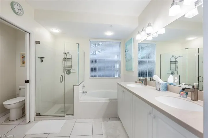 Full bathroom featuring toilet, independent shower and bath, and tile patterned flooring