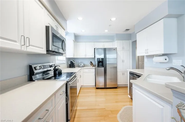 Kitchen featuring white cabinets, appliances with stainless steel finishes, sink, and light hardwood / wood-style floors