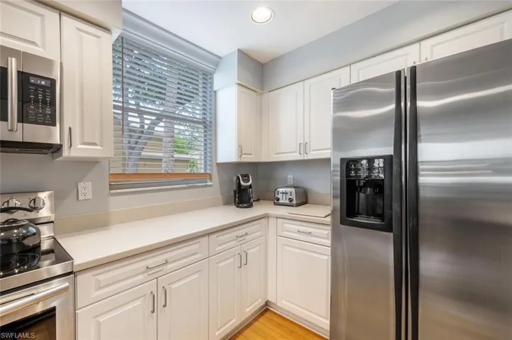 Kitchen featuring light hardwood / wood-style floors, white cabinetry, and appliances with stainless steel finishes