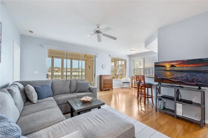 Living room featuring ceiling fan, a wealth of natural light, and light hardwood / wood-style flooring
