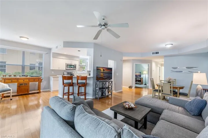 Living room with ceiling fan and light hardwood / wood-style flooring
