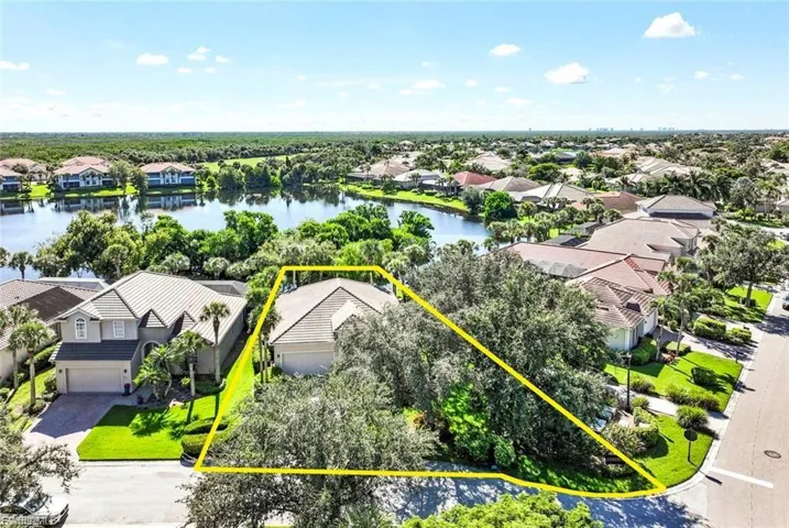 Aerial perspective of suburban area with property boundaries highlighted and a nearby body of water