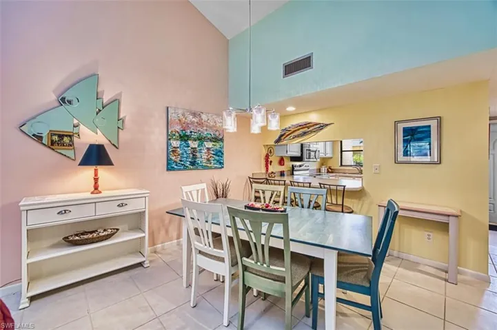 Dining area featuring light tile patterned floors and high vaulted ceiling