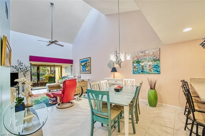 Dining room featuring high vaulted ceiling, light tile patterned flooring, ceiling fan, and recessed lighting