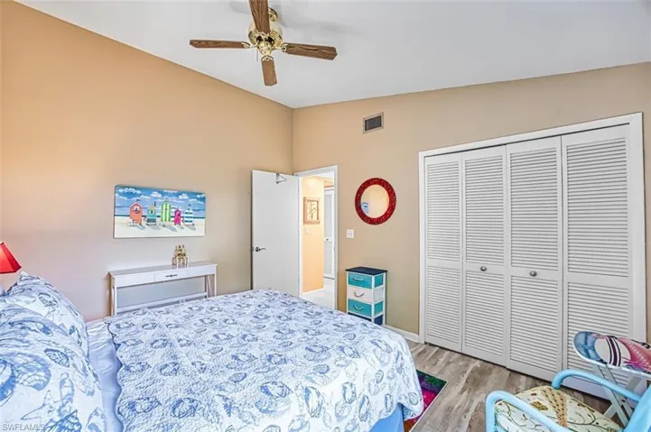 Bedroom with a ceiling fan, light wood-type flooring, a closet, and lofted ceiling