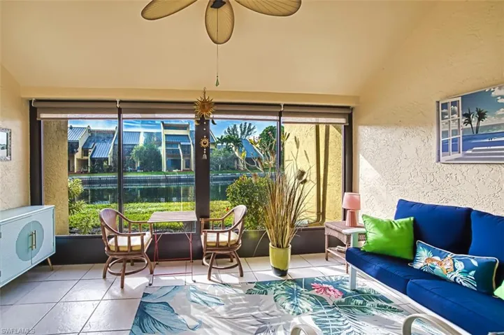 Sunroom / solarium with a textured wall, tile patterned floors, and vaulted ceiling