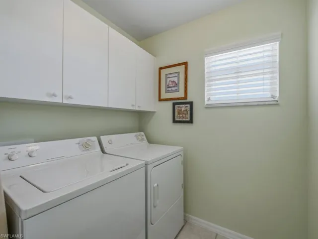 Washroom featuring separate washer and dryer and cabinet space