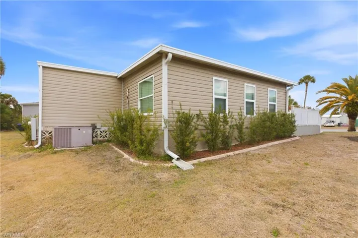 View of home's exterior featuring a lawn and a central air condition unit