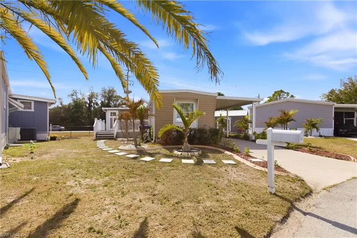 View of front facade with a carport and driveway
