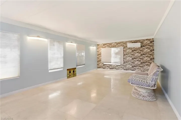 Empty room with crown molding and plenty of natural light