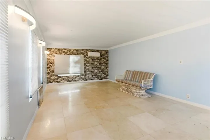 Unfurnished room featuring an accent wall and crown molding