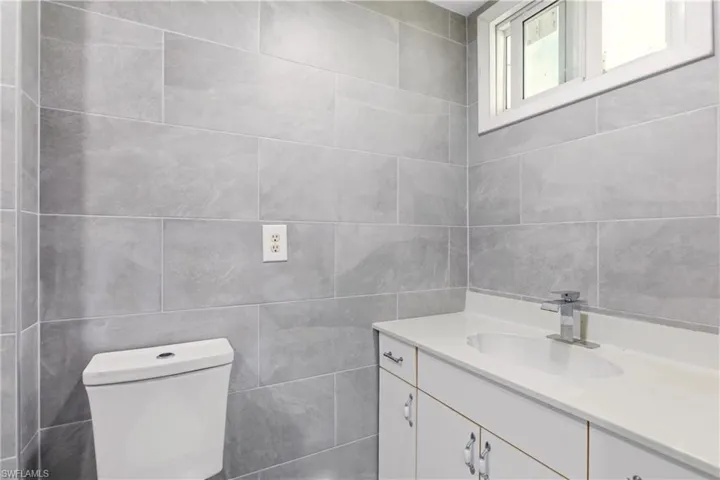 Bathroom featuring tile walls and vanity