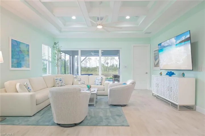 Living room with a healthy amount of sunlight, light hardwood / wood-style flooring, and ceiling fan