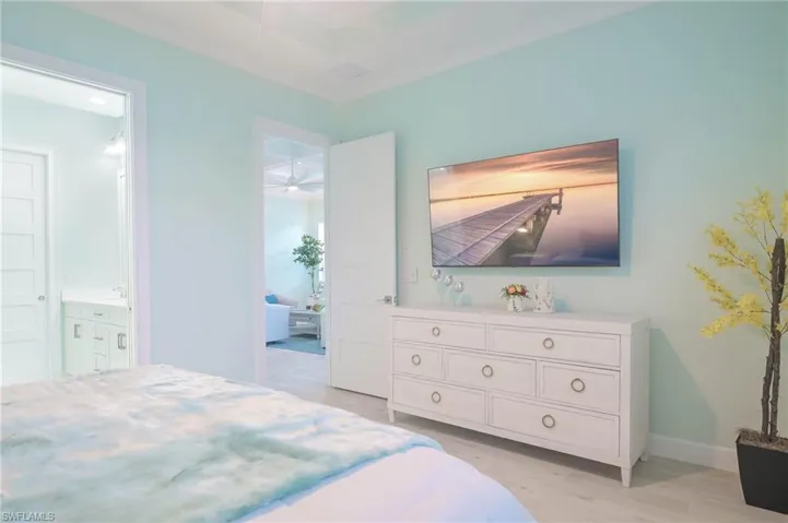 Bedroom with connected bathroom and light hardwood / wood-style floors