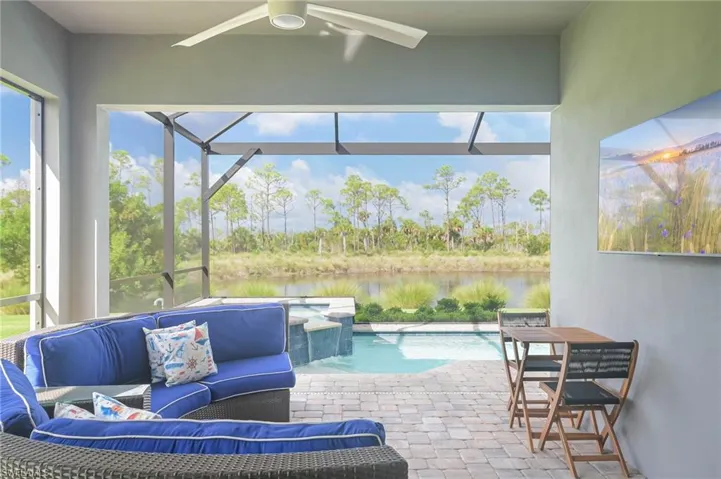 Sunroom / solarium with a water view, a swimming pool, ceiling fan, and a healthy amount of sunlight