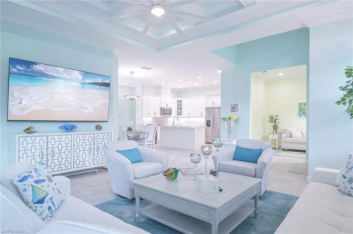 Living room featuring hardwood / wood-style flooring, sink, coffered ceiling, ceiling fan, and ornamental molding