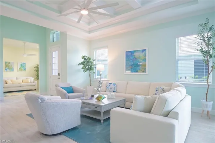 Living room featuring light hardwood / wood-style flooring, ceiling fan, coffered ceiling, and beam ceiling