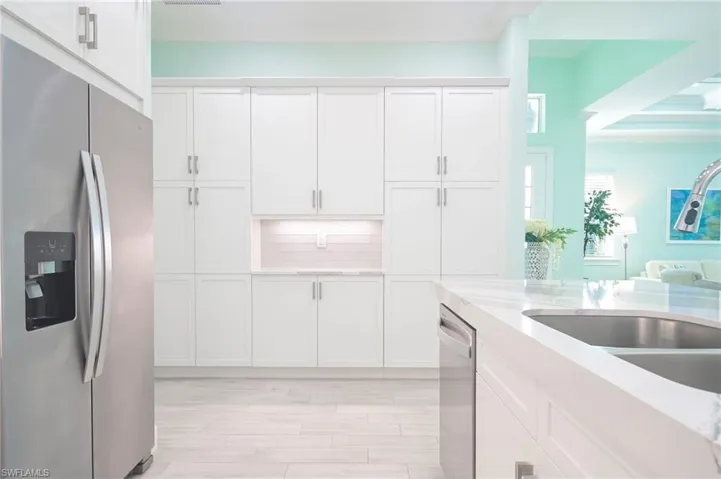 Kitchen featuring light wood-type flooring, white cabinetry, stainless steel appliances, sink, and decorative backsplash