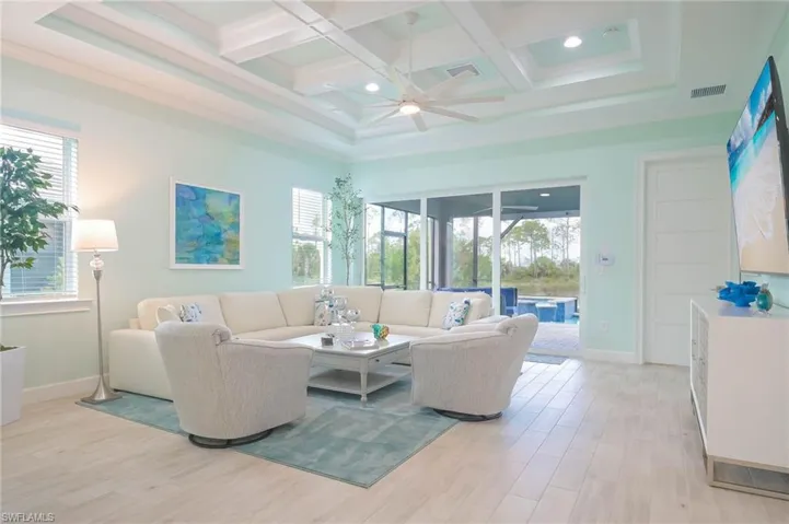 Living room with light wood-type flooring, a healthy amount of sunlight, and ceiling fan