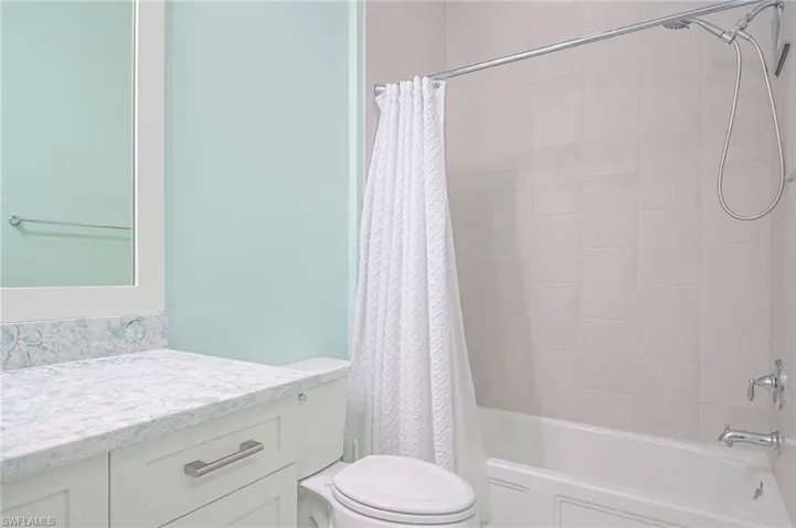 Full bathroom featuring vanity, toilet, and shower / tub combo with curtain