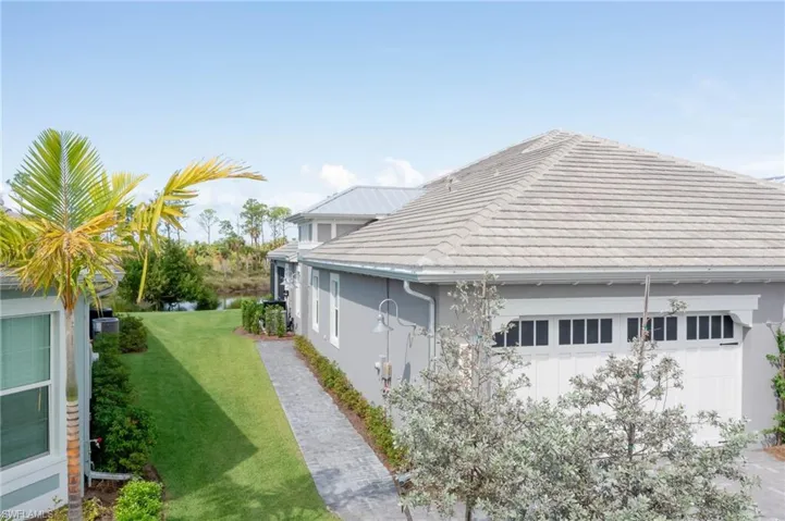 View of side of home featuring a garage and a lawn