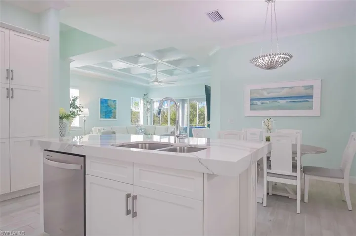 Kitchen featuring white cabinets, a center island with sink, sink, and dishwasher