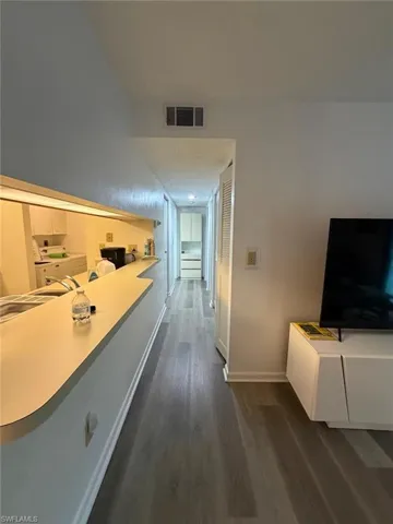 Corridor with dark wood-type flooring and washer / dryer