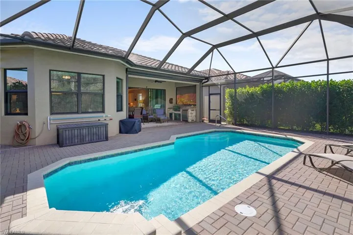 Outdoor pool with a patio, a sunroom, and a lanai