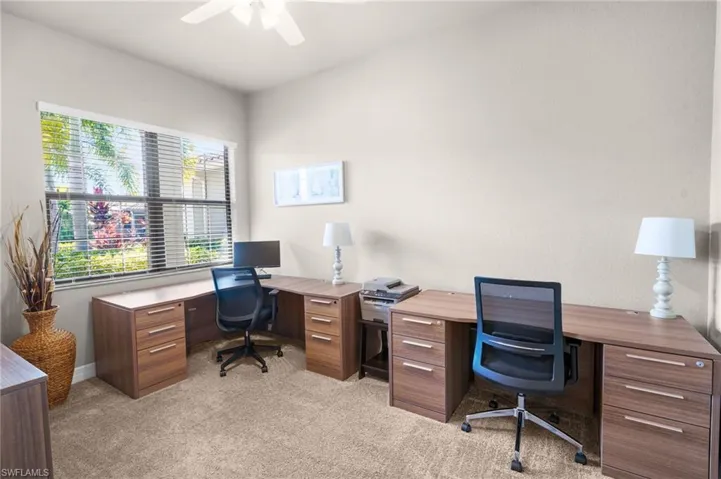 Office area with light colored carpet and ceiling fan