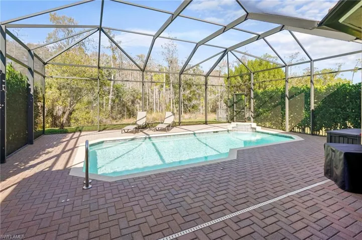 Outdoor pool with glass enclosure, a patio, and a sunroom