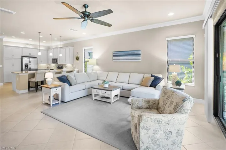 Living room featuring ornamental molding, a ceiling fan, recessed lighting, and light tile patterned flooring