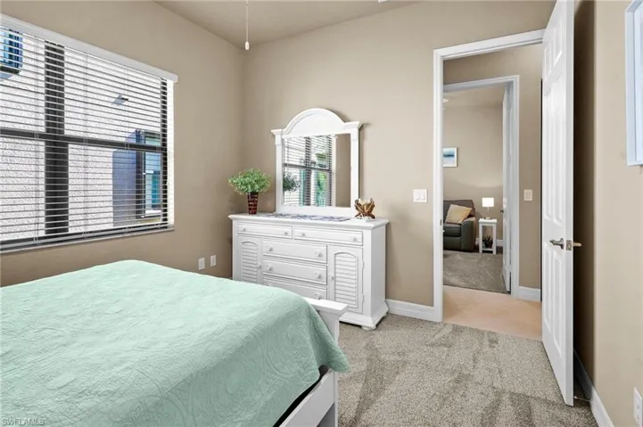Bedroom featuring light colored carpet and baseboards