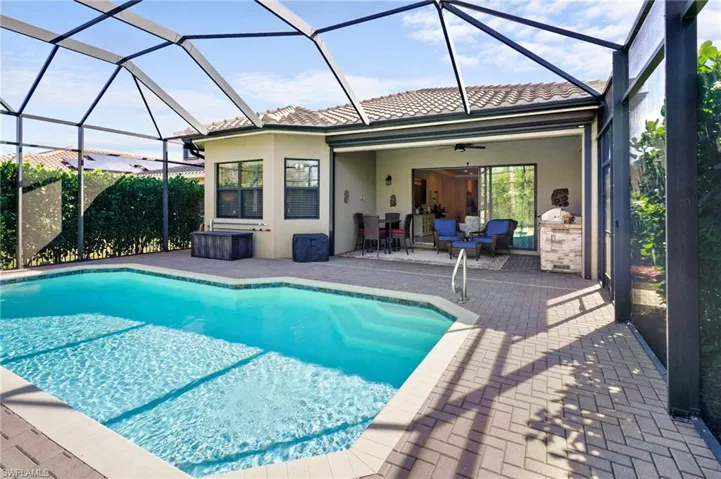 Swimming pool featuring a sunroom, a patio, and glass enclosure