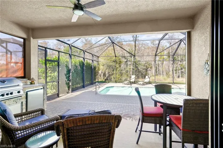 Sunroom featuring a patio, ceiling fan, exterior kitchen, and a swimming pool