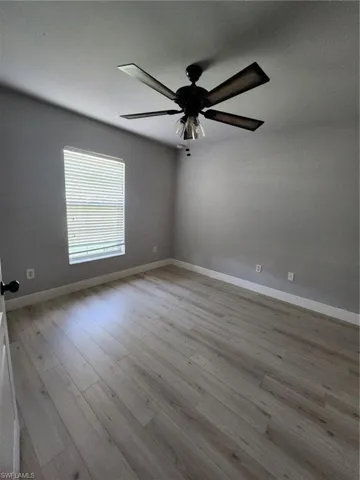 Unfurnished room with ceiling fan and light wood-type flooring