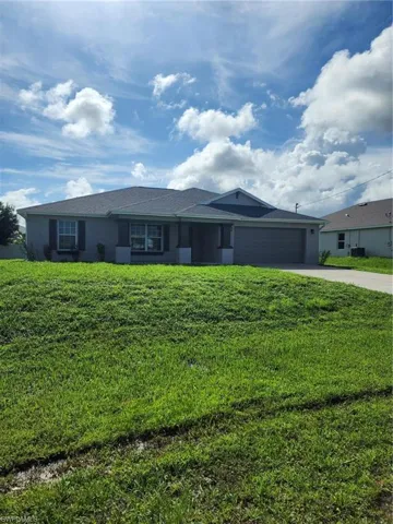 Single story home featuring a front lawn and a garage