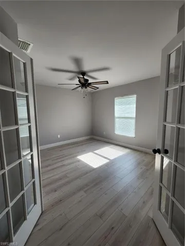 Unfurnished room with ceiling fan, french doors, and light hardwood / wood-style floors