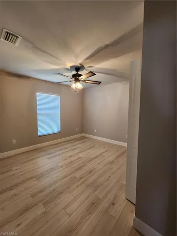 Empty room featuring ceiling fan and light hardwood / wood-style floors