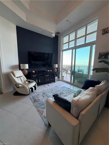 Tiled living area with ornamental molding and a tray ceiling