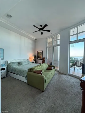Bedroom featuring carpet, a ceiling fan, access to outside, and a water view