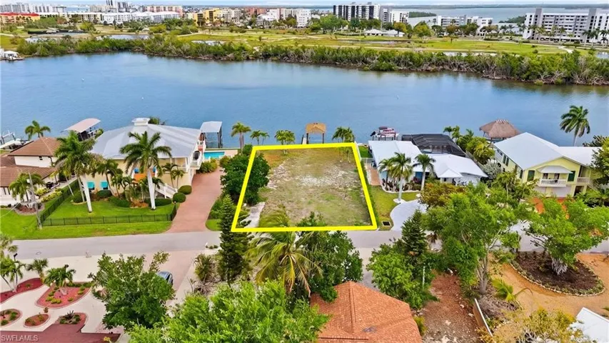 View of urban area featuring property parcel outlined, a large body of water, and nearby suburban area - Virtually Edited Image