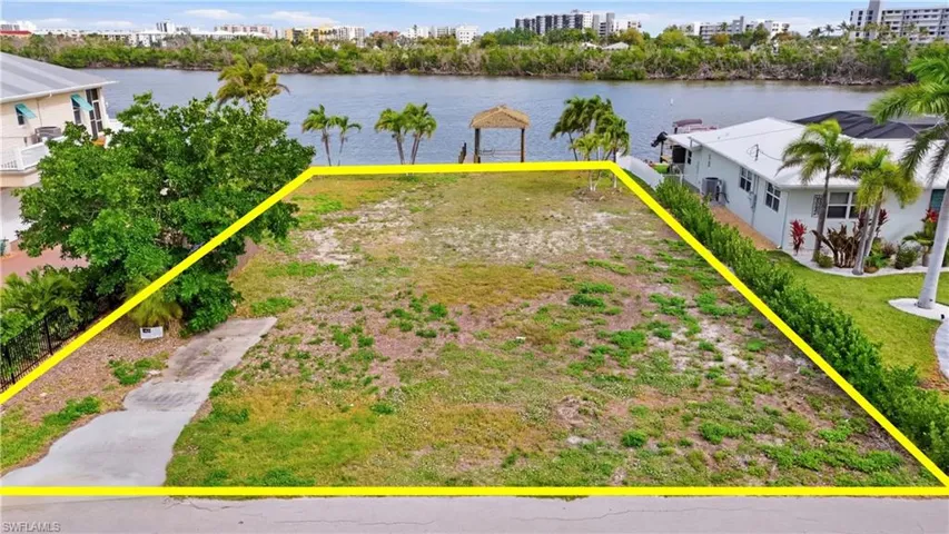 View of urban area with property boundaries highlighted and a large body of water - Virtually Edited Image