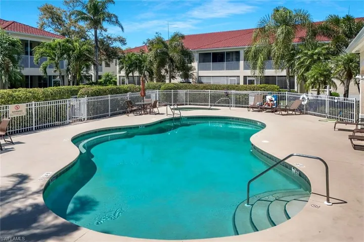 Community pool featuring a patio and fence