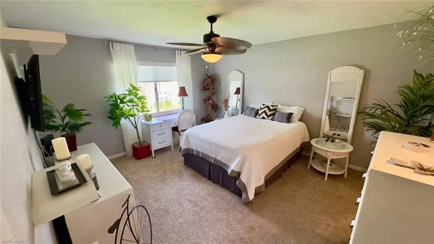 Primary bedroom with a window, a ceiling fan, and light gray walls