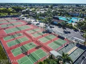 Expansive outdoor recreation area featuring multiple tennis courts, pickleball courts, and a large swimming pool complex