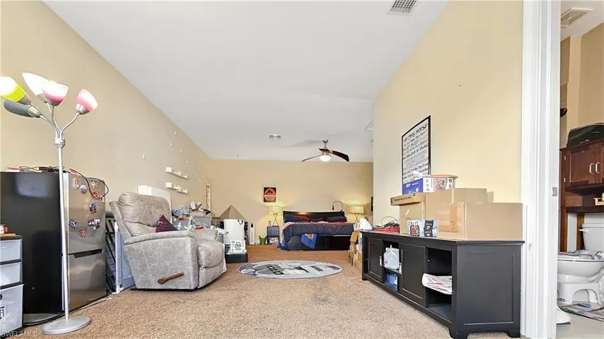 Carpeted living room with ceiling fan