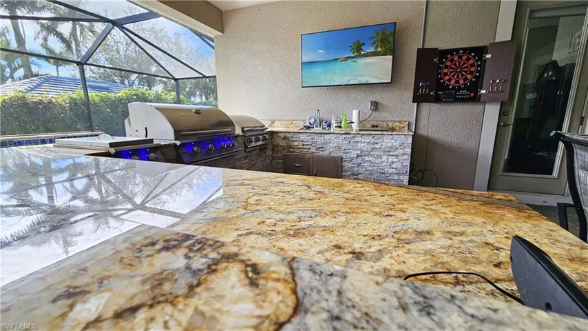 View of patio / terrace with an outdoor kitchen, a grill, and a lanai